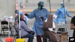 ARCHIVO - Un trabajador de salud hace una prueba de covid a un paciente en clínica campesina Martin Luther King Jr. en Homestead, Florida, el 6 de julio de 2020.