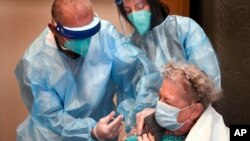 Bob Atighechi administers the COVID-19 vaccination to Margaret Dubois, 87, a resident at The Reservoir nursing facility, Friday, Dec. 18, 2020, in West Hartford, Conn. (AP Photo/Stephen Dunn, Pool)