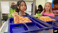 Students get lunch at the Albert D. Lawton Intermediate School, in Essex Junction, Vt., June 9, 2022. The pandemic-era federal aid that made school meals available for free to all public school students — regardless of family income levels — is ending. (AP Photo/Lisa Rathke)
