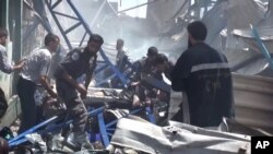 An image made from video posted online by the Shaam News Network, a loosely organized group opposed to Bashar Assad, Aug. 16, 2015, which has been verified and is consistent with other AP reporting, shows rescuers taking a victim from the site of Syrian government airstrikes in Douma, a suburb of Damascus, Syria.