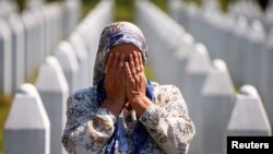 Srebrenitsa yaqinida genotsid qurbonlari qabristonida yig'layotgan ayol. Bosniya va Gersegovina, 11-iyul, 2020. 