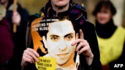 Berlinda namoyishchilar Saudiya Arabistoni elchixonasi oldida blogger Raif Badaviyning suratini ko'tarib chiqdi, 29-yanvar, 2015-yil.