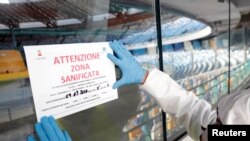 បុគ្គលិក​ម្នាក់​កែសម្រួល​ទីតាំង​ស្លាកសញ្ញា​នៅ​ស្តាត San Paolo នៅ​ក្នុង​ក្រុង Naples ប្រទេស​អ៊ីតាលី កាលពី​ថ្ងៃទី៤ ខែមីនា ឆ្នាំ២០២០។