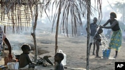 Children sit outside their family's tent as a neighbor bathes her son in a camp housing more than 2,600 Ivorian refugees, with more arriving daily, in Solo Town, near Zwedrou, Liberia, May 2011. (file photo)