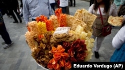 In this July 5, 2016 file photo, a street vendor sells fried snack food in Mexico City. (AP Photo/Eduardo Verdugo, File)