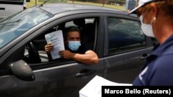 Čovek razgovara sa službenicom pošto je dobio formular za nezaposlene na Floridi (Foto: Reuters/Marco Bello) 