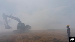 Un militar dirige una excavadora durante trabajos para extinguir un incendio en un vertedero en Villa Nueva, Guatemala, el martes 9 de abril de 2024. Según la agencia estatal guatemalteca que atiende las emergencias, CONRED, el 50 % del fuego está controlado.