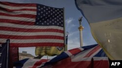 Прапори США, Британії та України на Майдані Незалежності у Києві 4 березня 2025 року біля імпровізованого меморіалу загиблим українським та іноземним бійцям внаслідок російського вторгнення в Україну. Фото: Roman Pilipey/AFP