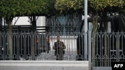 A soldier looks out from the City Hall compound in Yangon on Feb. 1, 2021, as Myanmar's military detained the country's de facto leader Aung San Suu Kyi and the country's president in a coup. 