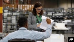 Empleados de la Oficina de Supervisión de Elecciones del Condado de Palm Beach (Florida) durante el conteo de boletas el 14 de noviembre de 2108.