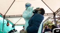 A health worker takes a nasal swab sample for a COVID-19 test, provided for free by the municipal government in Bogota, Colombia, Oct. 16, 2020.