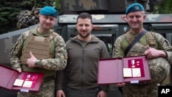In this photo provided by the Ukrainian Presidential Press Office, Ukrainian president Volodymyr Zelenskyy, center, poses for photo with soldiers after an awarding ceremony as he visits the Donetsk region, Ukraine, May 23, 2023.