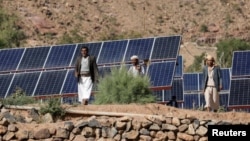 Farmers walk next to solar panels at a farmland in Wadi Dhahr near Sanaa, Yemen October 28, 2019. (REUTERS/Khaled Abdullah)