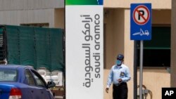 A security person wears a mask as he checks vehicles entering a compound for Saudi Aramco in Jiddah, Saudi Arabia, March 9, 2020. 