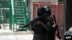 Policías haitianos hacen guardia en una esquina en medio de la violencia de pandillas en Puerto Príncipe el 8 de abril de 2024.