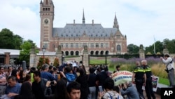 Demonstrators, police, and media gather outside the Peace Palace in The Hague, Netherlands, on Tuesday, July 12, 2016, ahead of a ruling by the Permanent Court of Arbitration (PCA) on the dispute between China and the Philippines over the South China Sea.