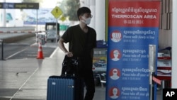 រូបឯកសារ៖ ទេសចរ​ម្នាក់​ពាក់ម៉ាស់​ ដើរ​ចូល​កន្លែង​វាស់​សីតុណ្ហភាព​នៅ​អាកាសយានដ្ឋាន​អន្តរជាតិ​ភ្នំពេញ ថ្ងៃ​ទី​៣ ខែមេសា ឆ្នាំ​២០២០។ 