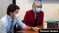 Le Premier ministre canadien Justin Trudeau et la ministre de la Santé Patty Hajdu examinent des flacons de vaccin COVID-19 à Ottawa, le 16 décembre 2020. (Reuters)