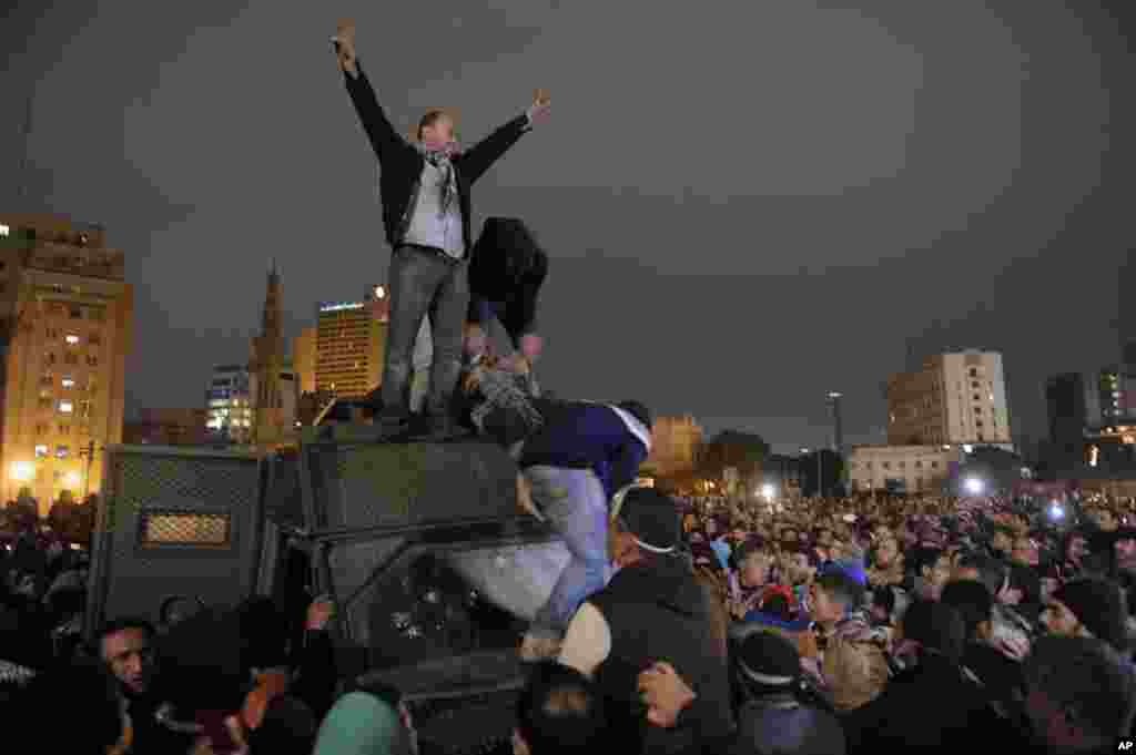 Protesters celebrate the capture of a state security armored vehicle that demonstrators commandeered during clashes with security forces and brought to nearby Tahrir Square in Cairo, Egypt, January 28, 2013.