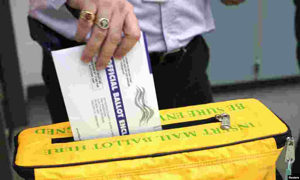 A voter deposits his ballot in the ballot box for the U.S. midterm elections at a polling place in Westminster, Colorado, Nov. 4, 2014. 