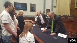 國會眾議院移民與邊境安全小組委員會主席、共和黨議員高迪(Rep. Trey Gowdy)與非法移民犯罪的受害者家屬羅拉威爾克森握手，共和黨議員史蒂芬.金（Rep. Steve King）與另一位家屬米歇爾如特交談。（美國之音魏之拍攝）
