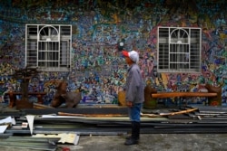 A man stands in front his home painted by Hakka graffiti artist Wu Tsun-hsien in the Taiwanese village of Ruan Chiao, March 30, 2019.