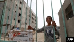 A boy stands at the gate to a section of the National Hospital that was being refurbished by Doctors Without Borders in the northern Syria city of Raqa on Oct. 13, 2018. 