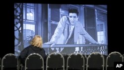 A woman watches the Elvis Presley film "King Creole" in a theater in the "Elvis Presley's Memphis" complex Thursday, March 2, 2017, in Memphis, Tenn. (AP Photo/Mark Humphrey)