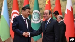 Rais wa China Xi Jinping (Kushoto), akisalimiana na mwenzake wa Misri, Abdel Fattah el Sisi mjini Beijing