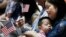 FILE - And immigrant from China holds her three-year-old son and a U.S. flag during a naturalization ceremony at the New York Public Library, in New York City, July 3, 2018. 