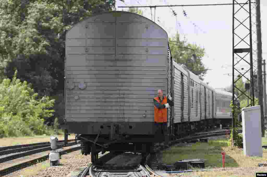 A guard rides on a train carrying the remains of victims of Malaysia Airlines MH17 downed over rebel-held territory in eastern Ukraine as it arrives in the city of Kharkiv, under Kyiv's control, July 22, 2014.