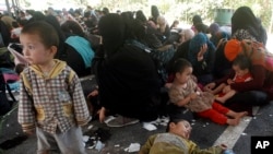 Suspected migrants being detained at a rubber plantation in Hat Yai district of Songkhla province southern Thailand Thursday, March 13, 2014. 