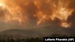 FILE - In this Friday, Aug. 6, 2021 file photo, smoke spreads over Parnitha mountain during a wildfire in the village of Ippokratios Politia, Greece, about 35 kilometres (21 miles), north of Athens. (AP Photo/Lefteris Pitarakis)