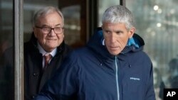 William "Rick" Singer, front, founder of the Edge College & Career Network, exits federal court in Boston on Tuesday, March 12, 2019, after he pleaded guilty to charges in a nationwide college admissions bribery scandal. 