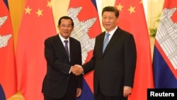 រូបឯកសារ៖ លោកនាយករដ្ឋមន្ត្រី ហ៊ុន សែន (ឆ្វេង) ចាប់ដៃ​ជាមួយ​លោក​ប្រធានាធិបតីចិន ស៊ី ជីនពីង មុន​កិច្ចប្រជុំនៅវិមានរដ្ឋាភិបាលចិនប្រចាំទីក្រុង​ប៉េកាំង ប្រទេស​ចិន ថ្ងៃទី២៩ ខែមេសា ឆ្នាំ២០១៩។ 