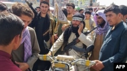 ადგილობრივი მოსახლეობით გარშემორტყმული თალიბი მებრძოლი, 11 აგვისტო, 2021 წელი. 