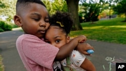 Zavion Guzman hugs his sister Jazzmyn, June 30, 2021, in Belleville, NJ. Lunisol Guzman adopted the two as babies but died last year from COVID-19 along with her partner at the start of the violent first wave of the pandemic.