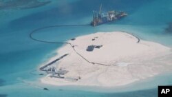 FILE - In this Feb. 25, 2014 file photo taken by surveillance planes and released May 15 by the Philippine Department of Foreign Affairs, a Chinese vessel, top center, is used to expand structures and land on the Johnson Reef, called Mabini by the Philippines. (AP Photo/Philippine Department of Foreign Affairs, File)