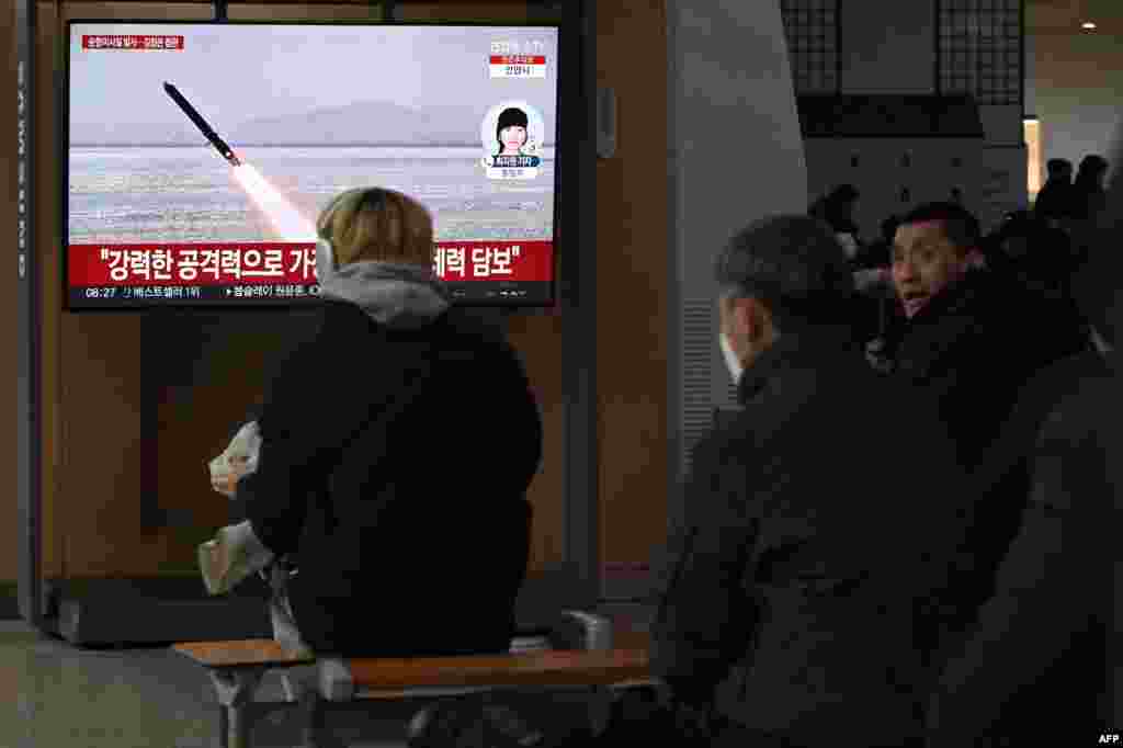 People watch a television screen showing news footage of North Korea's latest test-launch of strategic cruise missiles, at a train station in Seoul.