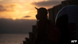 Un niño migrante cerca de la valla fronteriza de EE. UU. durante una vigilia para protestar contra la muerte de la migrante salvadoreña Victoria Esperanza Salazar, el 2 de abril de 2021.