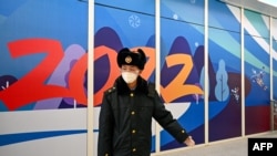 资料照片：在2022年北京冬季奥运会开幕前，一名中国安保人员在张家口太子城站的“闭环管理”“泡泡”区域内引导到达的乘客。（2022年1月29日）