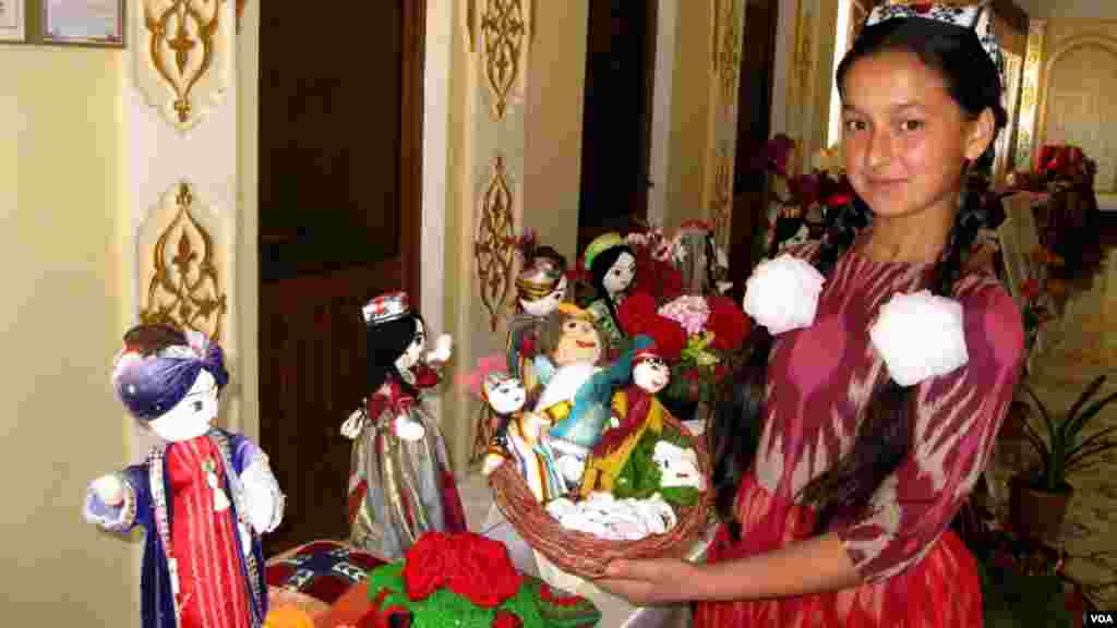 Qo'g'irchoqlarni tayyorlagan hunarmand qizcha.