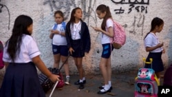 In this Feb. 4, 2019 photo, students arrive for their first day of school, in Rio de Janeiro, Brazil. Brazilian President Jair Bolsonaro is taking his anti-leftist ideological war to the country's classrooms and universities, causing angst among teachers. (AP Photo/Silvia Izquier
