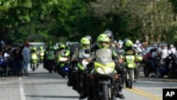 ARCHIVO - La policía escolta vehículos que viajan de Caucacia a Medellín, para ayudarlos a pasar con seguridad por Taraza, Colombia, el martes 14 de marzo de 2023.
