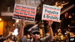 A man holds signs decrying police brutality in Hong Kong, Oct. 31, 2019. 