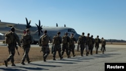 แฟ้ม: นาวิกโยธินสหรัฐฯ มุ่งหน้าไปยังฐานทัพเรือสหรัฐฯ ที่อ่าวกวนตานาโม ซึ่งเตรียมรับผู้อพยพที่หลั่งไหลเข้ามาจำนวนมาก กำลังเดินไปยังเครื่องบิน C-130 เฮอร์คิวลิส ในเมืองแจ็กสันวิลล์ รัฐนอร์ทแคโรไลนา 1 ก.พ. 2025 (U.S. Marine Corps/Cpl. Noela Vazquez/Handout via REUTERS)