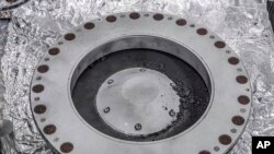 Esta fotografía proporcionada por la NASA el miércoles 11 de octubre de 2023 muestra la parte exterior del recolector de muestras Osiris-Rex con material del asteroide Bennu. 