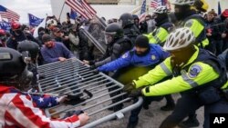 Trump supporters try to break through a police barrier, Jan. 6, 2021, at the Capitol in Washington. 