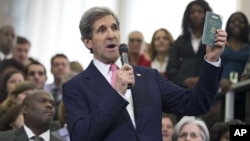 New Secretary of State John Kerry shows his first diplomatic passport he got when he was 11 years old when his father was in the foreign service, during a ceremony welcoming him as the 68th secretary of state, Feb. 4, 2013.