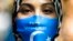 FILE - A woman wears a face mask reading 'Free Uyghurs' as she attends a protest during the visit of Chinese Foreign Minister Wang Yi in Berlin, Sept. 1, 2020. 